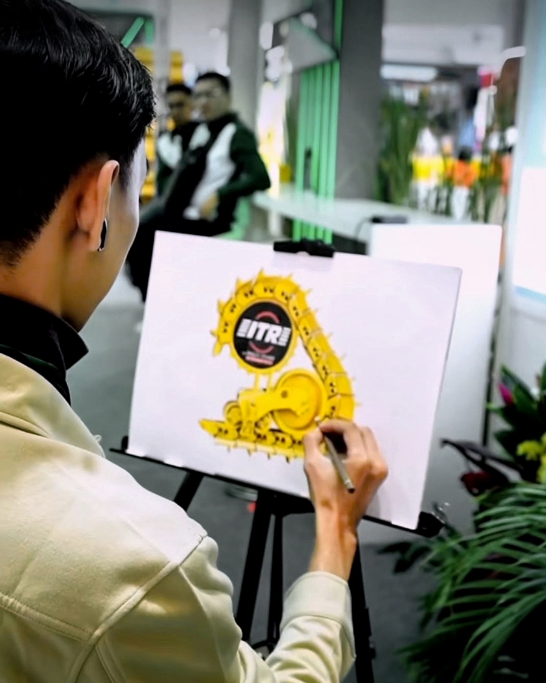 Live drawing performance at the Multi Power Aditama event, sketching a machine attachment on an easel